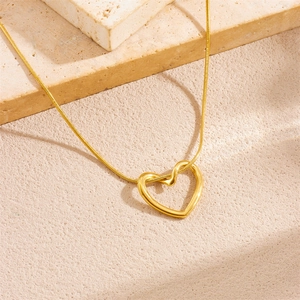 Minimalist gold plated heart chain necklace on natural textured stone background