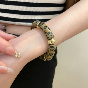 Close-up of iridescent leopard print acrylic bead bracelet with golden metallic accents