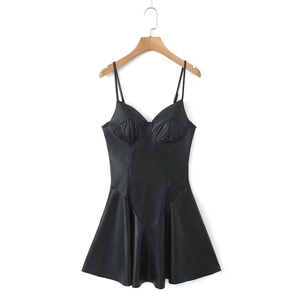 Detalle de vestido de cuero PU negro con copas plisadas y cintura entallada en percha de madera