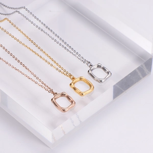 Three-color minimalist stainless steel square hollow pendants on acrylic display