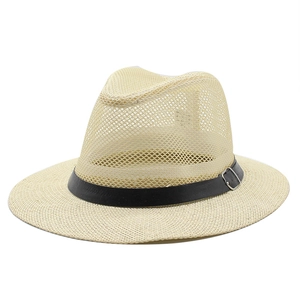 Detail of breathable mesh crown and black leather band on a summer straw fedora hat