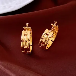 Luxury gold-plated crossover circular earrings on elegant red velvet background