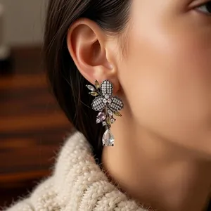 Orecchini vintage a fiore con zirconi colorati indossati da una modella di profilo