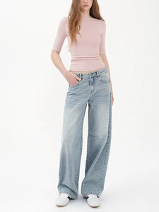 Detail of slim fit light pink round neck t-shirt paired with high-waisted wide-leg jeans