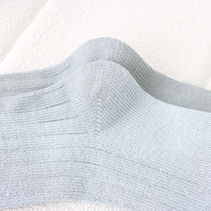 Close-up of gray-blue knit socks featuring detailed vertical stripes and woven texture