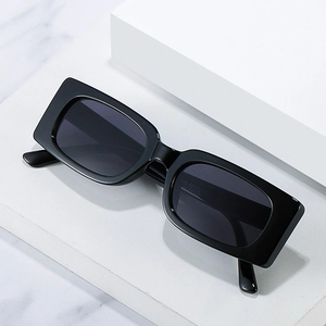 Retro rectangle sunglasses with high-gloss black frames and gray lenses on a white platform