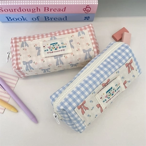 Close-up of checkered canvas pencil cases with cute fabric patches and top metal zippers