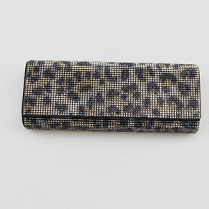 Macro shot of rectangular evening clutch featuring leopard pattern rhinestones on white base