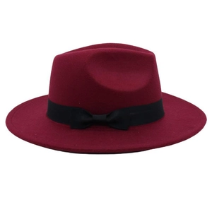 Detail of burgundy wool fedora hat featuring a black wide ribbon and bow decoration
