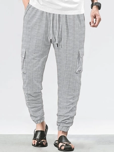 Detail of light grey cargo pants showing breathable knit texture and functional side pockets