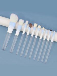 Detail of 11 gradient blue makeup brushes with transparent handles on a blue base