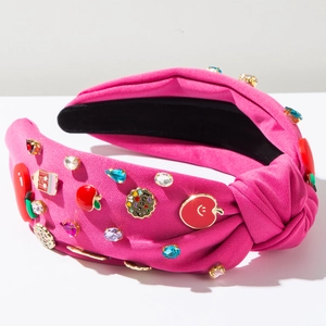 Detail of rose red knotted headband with colorful rhinestones and lucky charms