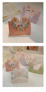 Close-up of mini cartoon greeting cards with heart-shaped folds and animal designs