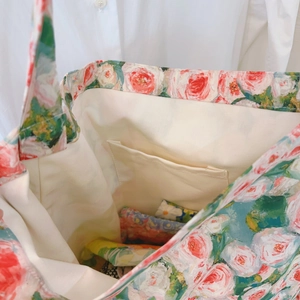 Dettaglio interno della borsa in tela con tasca aperta e stampa a rose rosse vivaci