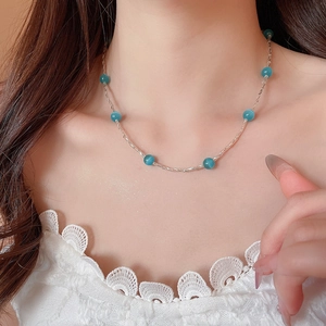 Dettaglio della collana a maglie argento con perline occhio di gatto blu su pizzo