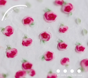 Detail of floral nail stickers featuring pink watercolor roses and green leaves on texture