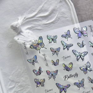 Holographic laser butterfly nail art stickers with intricate black outlines on white background