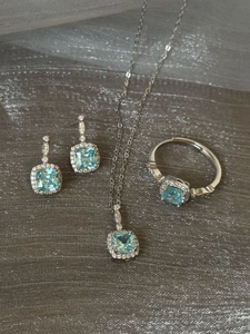 Detailed flat lay of sea blue square gemstone necklace earrings and ring jewelry set