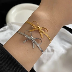 Set di bracciali con fiocco in oro e argento sul polso per uno stile dolce