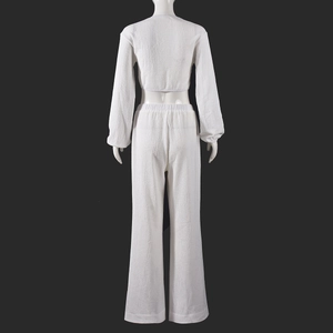 Vue arrière d'un ensemble deux pièces blanc avec cardigan court plissé et pantalon large