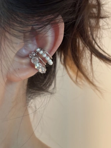 Détail du bijou d'oreille argenté avec perles blanches et pierres de zircone brillantes