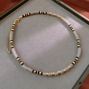Detail of gray agate beaded necklace with gold metal accents and lobster clasp closure
