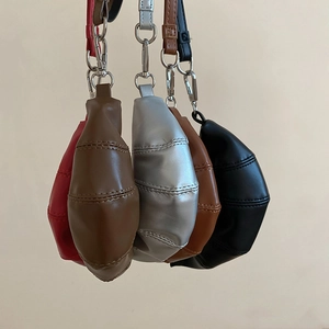 Gros plan de cinq mini sacs croissants colorés en cuir avec détails de surpiqûres