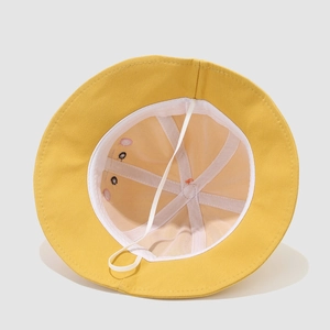 Détail d'un chapeau de soleil jaune pour enfant avec doublure en maille et mentonnière