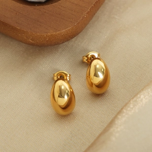 Minimalist gold teardrop earrings with mirror polish finish on silk background