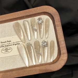 Champagne cat-eye press-on nails with luxury crystals and chain on velvet background