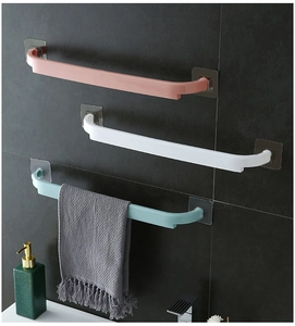 Wall-mounted towel rack in pink, white, and blue on dark grey tile bathroom wall