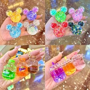 Dettaglio di portachiavi in acrilico con vari design di bottiglie e bicchieri di soda