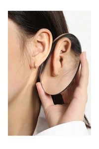 Detailed view of gold S925 sterling silver hoop earrings with hammered texture on model