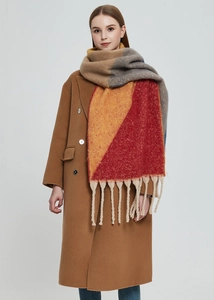 Detailed view of colorful knit scarf with thick fringe tassels on a fashion model