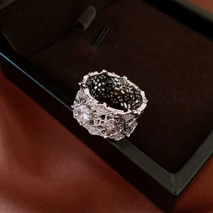Macro shot of silver hollow-out ring with a large zircon stone on black velvet box