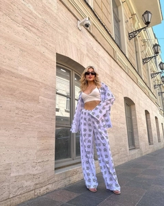 Detail of white two-piece lounge set with black print on wide-leg pants and long-sleeve shirt