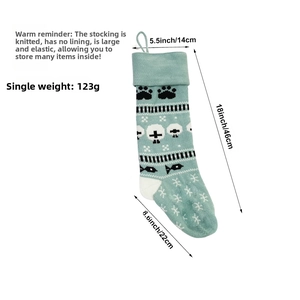 Detail of mint green knitted Christmas sock with dimensions and cat paw pattern