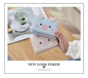 Close-up of cute cartoon pig short tri-fold wallets in pastel pink and light blue PU leather