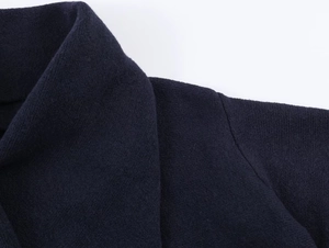 Detailed close-up of dark blue knit fabric showing texture and stitching quality