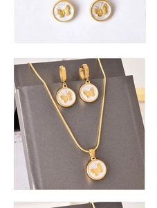 Detail of gold butterfly pendant necklace and earrings set on a jewelry display