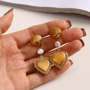 Detail of 18K gold heart locket earrings with faux pearl and shell clip design