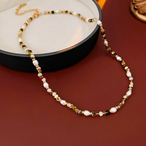 Detail of freshwater pearl necklace with vintage stone beads and gold metal chain