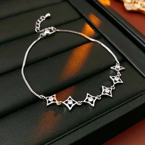 Détail du bracelet avec breloques étoiles argentées et incrustations de zircons blancs