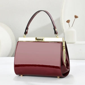 Detailed close-up of red snakeskin leather evening bag with golden metal top handle