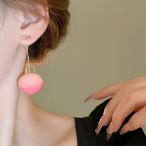Close-up of elegant gradient pink peach resin dangle earrings worn by a model