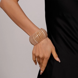 Détail du bracelet large élastique en acrylique marbré beige au style vintage chic