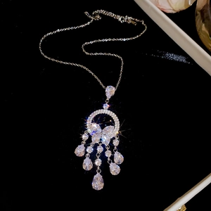 Vue macro d'un collier à pendentif fleur argenté avec pompons et cristaux étincelants