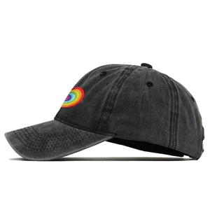 Detail of colorful rainbow spiral embroidery on washed black cotton baseball cap fabric