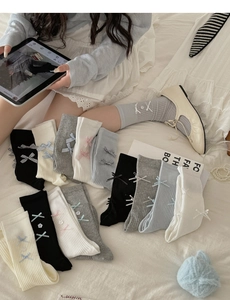 Detail of ballet style rib-knit mid-calf socks with ribbon bows and Mary Jane shoes