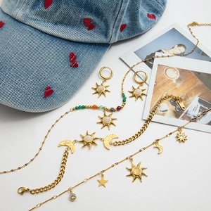 Bohemian gold celestial jewelry set with sun and moon pendants on white background